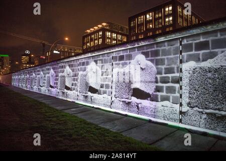 Berlin, Deutschland. 05 Nov, 2019. An der East Side Gallery, die historischen Ereignisse der Fall der Berliner Mauer sind in kurzen Geschichten über so genannte Projektion Mapping erzählt. In ganz Berlin, die Ereignisse der friedlichen Revolution und die Öffnung der Mauer wird an sieben ursprünglichen Standorte mit großen 3D-Projektionen aus historischen Bildern und Videos in Kombination mit Licht und Sound Effekte gezeigt werden. Quelle: Jörg Carstensen/dpa/Alamy leben Nachrichten Stockfoto