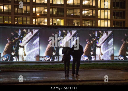 Berlin, Deutschland. 05 Nov, 2019. An der East Side Gallery, die historischen Ereignisse der Fall der Berliner Mauer sind in kurzen Geschichten über so genannte Projektion Mapping erzählt. In ganz Berlin, die Ereignisse der friedlichen Revolution und die Öffnung der Mauer wird an sieben ursprünglichen Standorte mit großen 3D-Projektionen aus historischen Bildern und Videos in Kombination mit Licht und Sound Effekte gezeigt werden. Quelle: Jörg Carstensen/dpa/Alamy leben Nachrichten Stockfoto