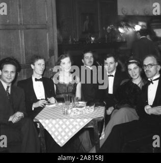 1950er Jahre, historische Erwachsene, die an einer Abendveranstaltung mit schwarzer Krawatte sitzen zusammen an einem Tisch in einem holzgetäfelten Veranstaltungsraum in England, Großbritannien. Stockfoto