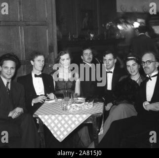 1950er Jahre, historische Erwachsene, die an einer Abendveranstaltung mit schwarzer Krawatte sitzen zusammen an einem Tisch in einem holzgetäfelten Veranstaltungsraum in England, Großbritannien. Stockfoto