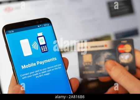 Über ein Mobiltelefon mit einer Zahlung per Kreditkarte online zu machen. Konzept - mobile Zahlungen und Betrug Stockfoto