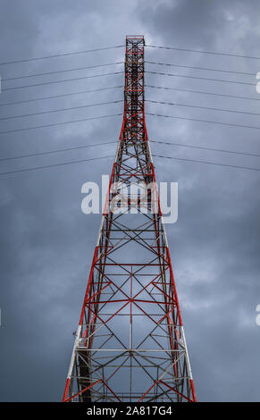 Hohe Spannung elektrische Pole und Übertragungsleitungen. Energieeinsparung. Atmosphäre und dunklen Hintergrund. Kraft und Energie. Stockfoto