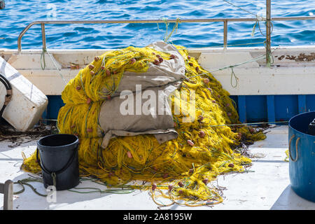 Fischernetze. Industriellem gelb Netze in einem Stapel auf Deck ist ein Fischerboot. Stock Bild. Stockfoto