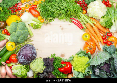 Sortiment von bunten Bio Gemüse im Rahmen angeordnet, Kohl Tomaten Möhren Brokkoli Blumenkohl squash Paprika Knoblauch. Gesund Hintergrund, Ansicht von oben, selektiver Fokus Stockfoto