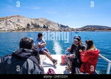 Touristen auf dem oberen Deck des Schiffes aus dem Hafen der Challa Gemeinschaft Seite der Insel der Sonne im Titicacasee, Bolivien sitzen Stockfoto