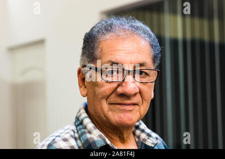 Älterer Mann genießt vor seinem Haus am frühen Morgen Sonnenlicht Stockfoto