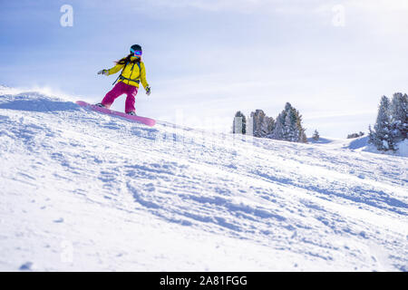 Athlet Frau in Helm Snowboarden im Winter Resort am Nachmittag Stockfoto