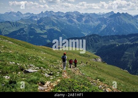Bergwanderer Abstieg vom Gipfel des Hohen Ifen, hinter Bergen der Allgäuer Alpen, in der Nähe von Hirschegg, Kleinwalsertal, Vorarlberg, Österreich Stockfoto