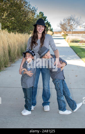 Eine junge Mutter steht mit ihrem jungen Söhne in diesem Spaß, Casual Family Portrait Stockfoto