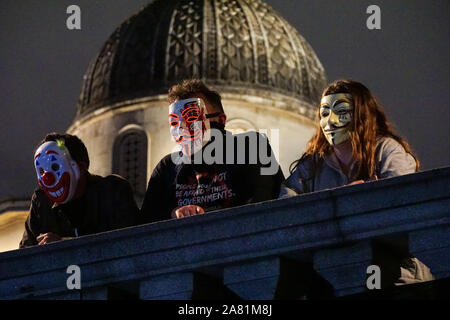 Menschen, die Guy Fawkes Masken tragen, beim jährlichen "Million Mask March" in Trafalgar Square, London England Großbritannien Stockfoto