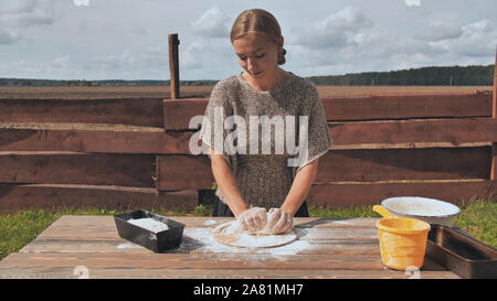 Eine junge Frau knetet den Teig mit den Händen. Hausgemachtes Brot backen. Stockfoto