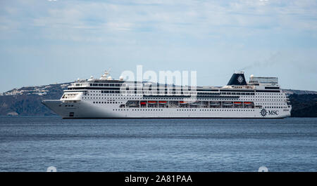 Fira, Griechenland - 16. Juli 2019: Die Schweizerische Kreuzfahrtschiff MSC Sinfonia in der Ägäis verankert an der Küste von Santorini in der Nähe der Fira Stockfoto