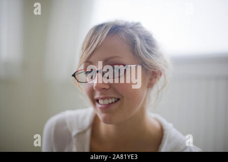 Porträt der jungen erwachsenen Frau mit Brille in einem Raum. Stockfoto