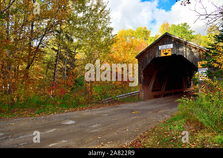 Ein Herbst Landschaft Bild von einem ikonischen Covered Bridge crossing Trout Creek auf einer Schotterstraße in der Nähe des ländlichen Sussex New Brunswick Kanada. Stockfoto