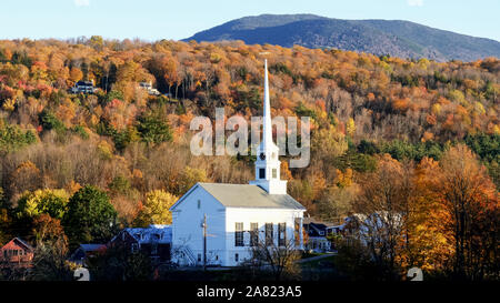 Eine weiße Neu-England Kirche mit einem Hügel im Herbst Laub bei Stowe in Vermont abgedeckt Stockfoto