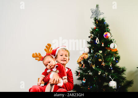 Kleinkind und Baby, Geschwister getarnt als Weihnachten, urlaub Konzept Stockfoto