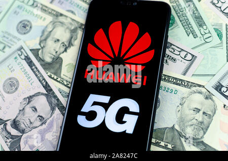 Huawei Logo auf dem Smartphone, das auf dem US-Dollar platziert ist. Konzeptionelle Foto für Huawei Gewinne aus ihren 5G-Netzen. Stockfoto