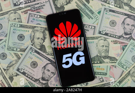Huawei Logo auf dem Smartphone, das auf dem US-Dollar platziert ist. Konzeptionelle Foto für Huawei Gewinne aus ihren 5G-Netzen. Stockfoto