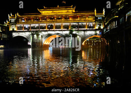 Ein hell erleuchteter Phoenix Hong Brücke, beeinflusst von traditionellen Chinesischen archicture, Bögen über den Tuo Jiang River in Fenghuang antike Stadt in Tibet Stockfoto