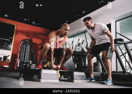 Aufgeregt trainer Schreien während motivierender afrikanische amerikanische Sportler Gewicht anheben Stockfoto