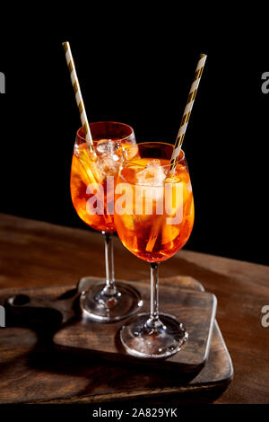 Aperol Spritz in Gläsern mit Strohhalmen auf Holz Schneidebretter Stockfoto