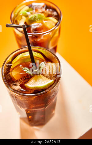 Selektiver Fokus der Cocktail cuba libre in Glas mit Stroh auf Cube Stockfoto