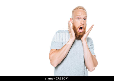 Stattliche schockiert Mann im grauen T-Shirt, isoliert auf weißem Stockfoto