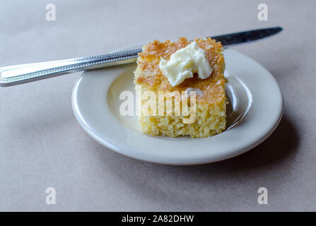 Mais Brot frisch aus dem Ofen mit Butter und Butter Messer Stockfoto