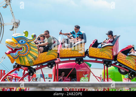 Battle Creek Michigan USA Juli 4, 2019; Eltern sitzen mit jungen Kindern, auf dieses lustige Achterbahnfahrt auf dem Gebiet der Flug Ereignis Stockfoto