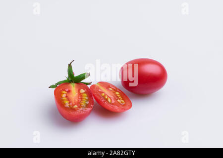 Traubenmost oder Kirsche tomate Zweig. Stapel der roten Trauben Tomaten auf weißem Hintergrund, weiches Licht, Winkel, Studio gedreht. Stockfoto