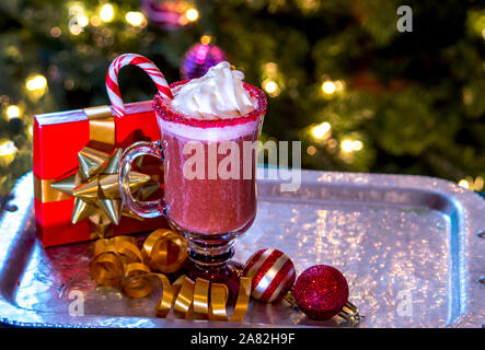 Sahne und eine Zuckerstange sind die perfekte Beilage für diese rote, gefroren Weihnachten Cocktail Stockfoto