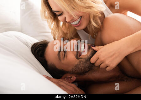 Lachende Frau glücklich Freund umarmen im Bett am Morgen Stockfoto