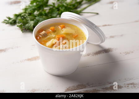 Gemüsesuppe in einem Einwegflaschen aus Plastik Schüssel mit Deckel, auf weißem Hintergrund. Schnell & einfach essen Konzept. Essverhalten, Lebensmittel-lieferservice. Stockfoto