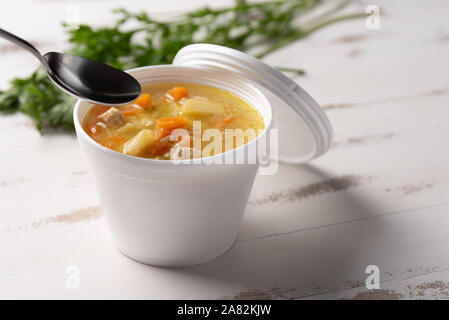 Gemüsesuppe in einem Einwegflaschen aus Plastik Schüssel mit Deckel, auf weißem Hintergrund. Schnell & einfach essen Konzept. Essverhalten, Lebensmittel-lieferservice. Stockfoto
