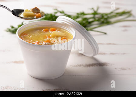 Gemüsesuppe in einem Einwegflaschen aus Plastik Schüssel mit Deckel, auf weißem Hintergrund. Schnell & einfach essen Konzept. Essverhalten, Lebensmittel-lieferservice. Stockfoto