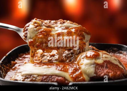 Parmegiana Steak isoliert auch als Filet Parmegiana in einem schwarzen Eisen bekannt Pan auf Holz Feuer Hintergrund unscharf, Käse und Tomatensauce. Soft l Stockfoto