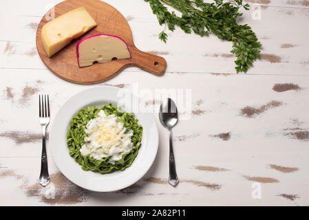 Hausgemachte greeen Spinat Bandnudeln mit béchamelsoße Soße in eine weiße Platte, rustikalen Holztisch Hintergrund, weiches Licht. Italienisches Essen Stil Stockfoto