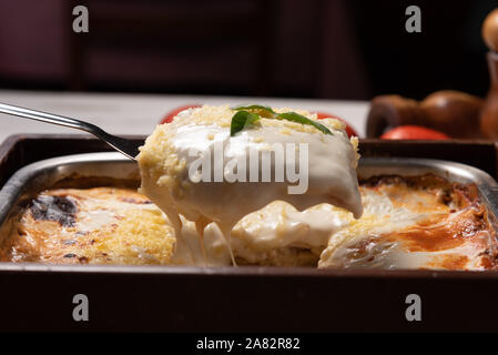 Lecker Lasagne mit Hackfleisch und Bechamelsauce Sauce Bolognese Sauce garniert mit Basilikum, weiches Licht Stockfoto