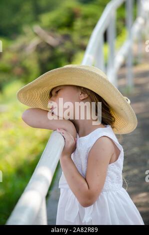 Tag träumen Kind in einem großen Schlapphut und einem weißen sundress Stockfoto