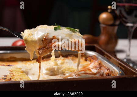 Lecker Lasagne mit Hackfleisch und Bechamelsauce Sauce Bolognese Sauce garniert mit Basilikum, weiches Licht Stockfoto