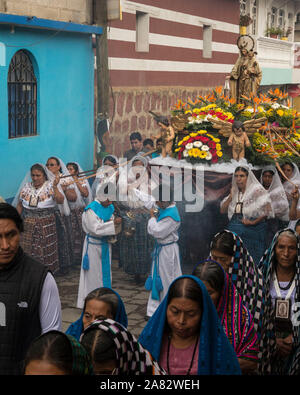 Junge Ministranten swing Räuchergefäße in der Katholischen Prozession der Jungfrau von Carmen in San Pedro La Laguna, Guatemala. Frauen in traditionellen Mai Stockfoto