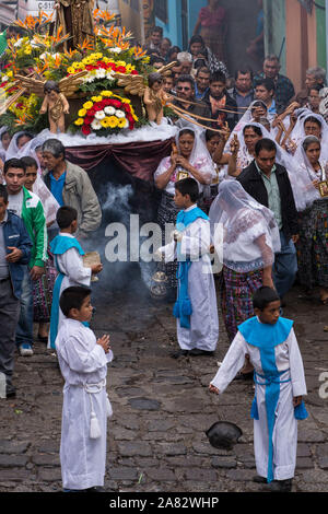 Junge Ministranten swing Räuchergefäße in der Katholischen Prozession der Jungfrau von Carmen in San Pedro La Laguna, Guatemala. Frauen in traditionellen Mai Stockfoto