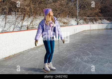 Reizende junge Frau, Schlittschuhe auf der Eisbahn. Stockfoto