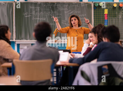 02. Dezember 2016, Hessen, Frankfurt/Main: Lehrer Nurdagül Ceri spricht mit den Studenten einer siebten Klasse an der Ernst-Reuter-Schule in Frankfurt während der Islamischen Lehren. Das Land Hessen hat seit Monaten über die Zusammenarbeit mit dem umstrittenen türkischen Moschee verband Ditib in islamischen Religionsunterricht. Um für die ditib der Rückzug vorbereitet zu sein, hat das Land mit dem neuen Thema der islamischen Unterricht Seit diesem Schuljahr in der alleinigen Verantwortung des Staates für die Schülerinnen und Schüler in Klasse 7. Foto: Frank Rumpenhorst/dpa Stockfoto