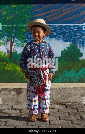 Junge Maya Junge, 6 Jahre, das Tragen der traditionellen Kleidung der San Pedro La Laguna, Guatemala, stellt sich in einem Porträt vor einer gemalten Wandbild. Stockfoto