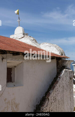 Rückansicht des kleinen, einfachen Katholische Kirche in Santa Cruz la Laguna, Guatemala mit Außentreppe und ein Kreuz mit einer Flagge gekrönt. Stockfoto