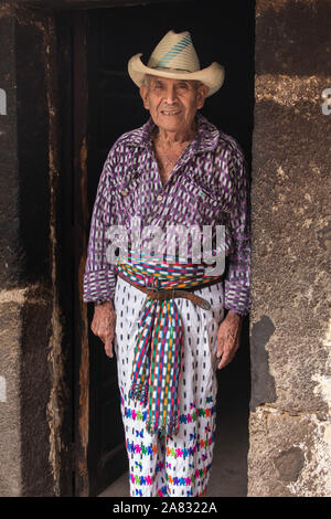 Jahr 90 alte Tzutujil Maya Mann in traditioneller Kleidung steht in der Tür von seinem Haus in San Pedro La Laguna, Guatemala. Stockfoto