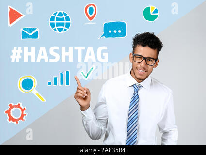 Afro-amerikanische Geschäftsmann an Hashtag und digitale Symbole Stockfoto