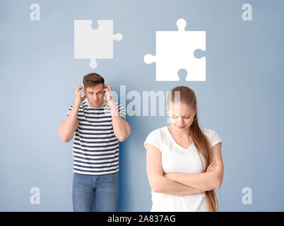 Junge stritten sich Paar und Stücke von Puzzle auf blauem Hintergrund Stockfoto