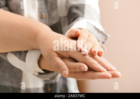 Junge Frau die Hand ihrer Großmutter, Nahaufnahme. Konzept der Pflege und Betreuung Stockfoto